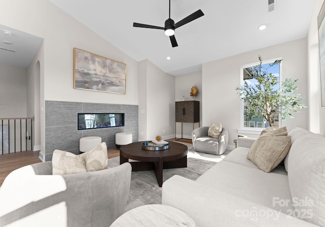 living room with ceiling fan, lofted ceiling, and light hardwood / wood-style floors