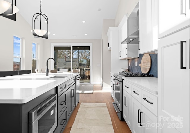 kitchen with tasteful backsplash, pendant lighting, white cabinets, and appliances with stainless steel finishes