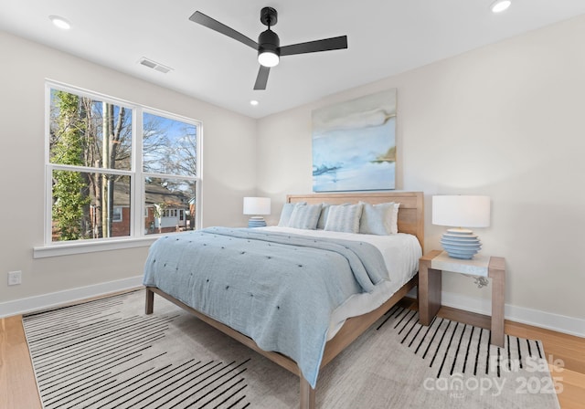 bedroom with multiple windows, light wood-type flooring, and ceiling fan