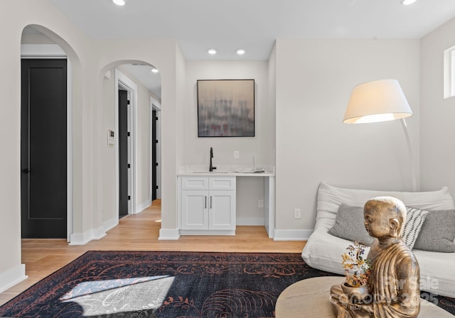 sitting room with indoor wet bar and light hardwood / wood-style floors