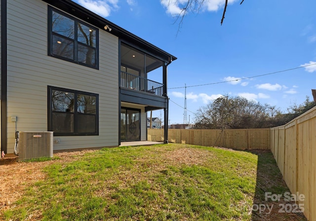 back of property with a lawn and central air condition unit