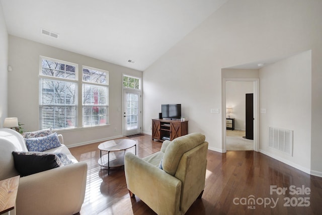 living room featuring dark hardwood / wood-style floors and high vaulted ceiling