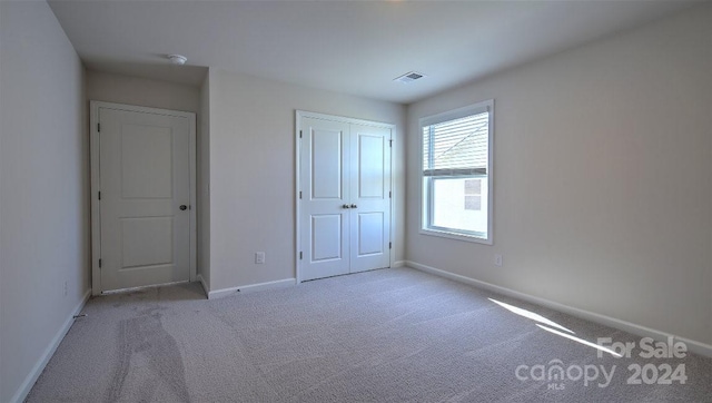 unfurnished bedroom with light colored carpet