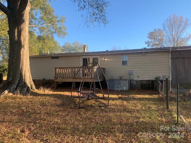 back of house with cooling unit and a deck