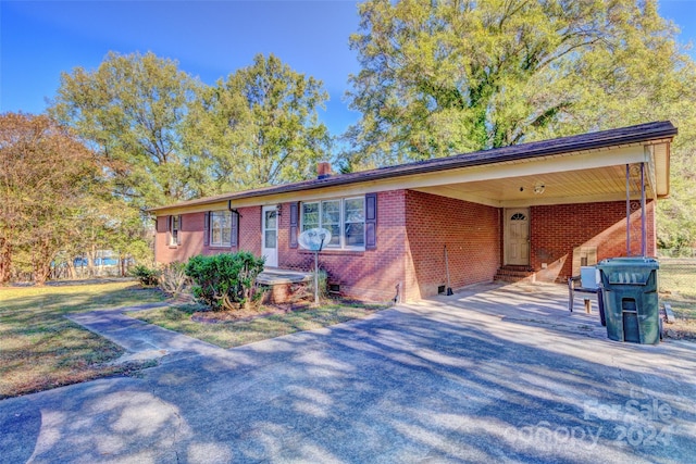 ranch-style home with a carport and a front yard