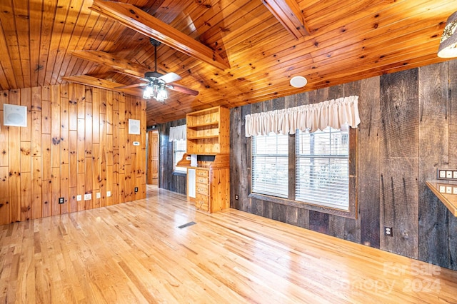 unfurnished living room featuring vaulted ceiling with beams, wood walls, hardwood / wood-style floors, and wooden ceiling