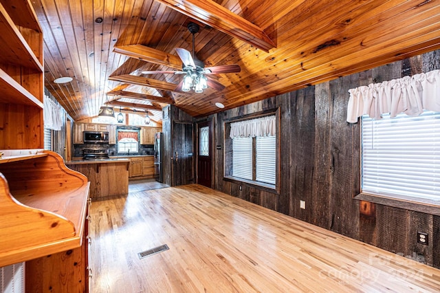 interior space featuring wood walls, lofted ceiling with beams, and wooden ceiling