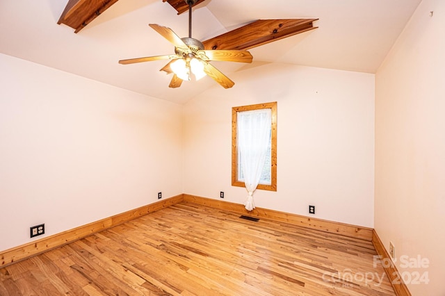 empty room featuring light hardwood / wood-style floors, vaulted ceiling, and ceiling fan