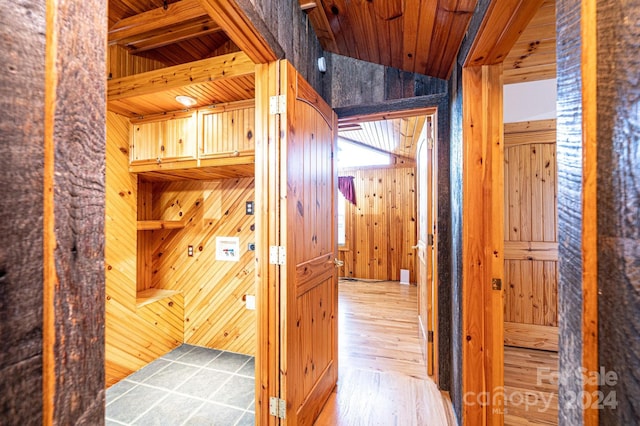 corridor with wood walls, wood-type flooring, and wooden ceiling