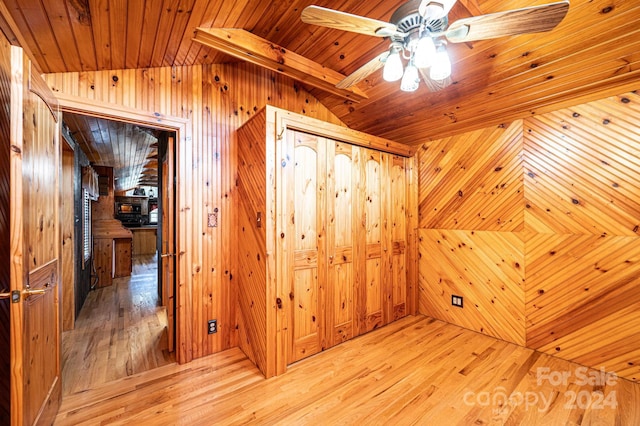 bonus room featuring vaulted ceiling with beams, wood walls, and light hardwood / wood-style flooring