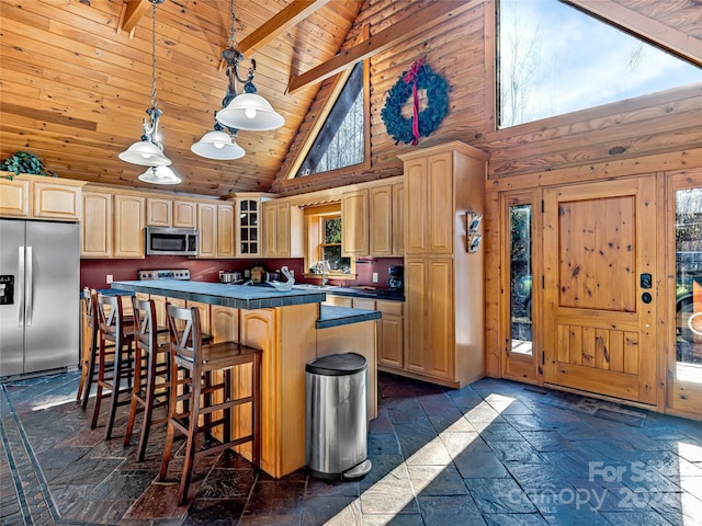 kitchen with appliances with stainless steel finishes, high vaulted ceiling, light brown cabinetry, and beam ceiling