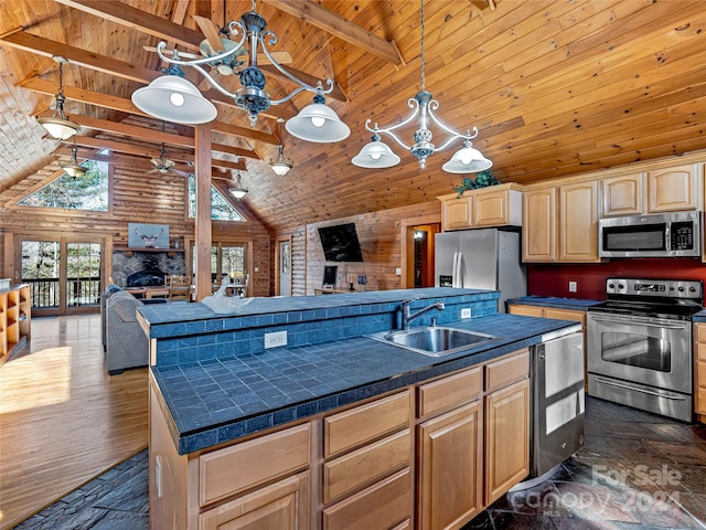 kitchen with a center island, light brown cabinets, sink, appliances with stainless steel finishes, and beamed ceiling