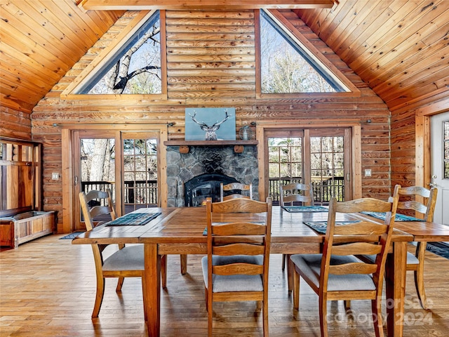 dining space with hardwood / wood-style flooring, a healthy amount of sunlight, and high vaulted ceiling