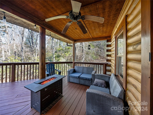 wooden terrace featuring an outdoor living space with a fire pit