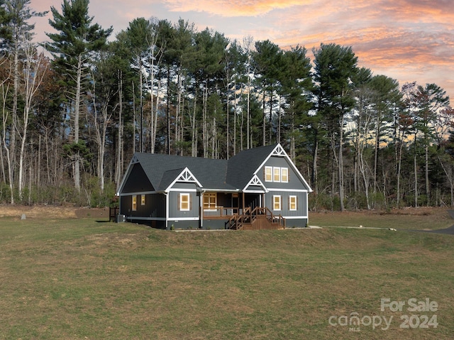 view of front of home with covered porch and a yard