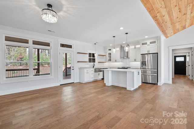 kitchen with white cabinetry, stainless steel fridge with ice dispenser, hanging light fixtures, and light hardwood / wood-style floors