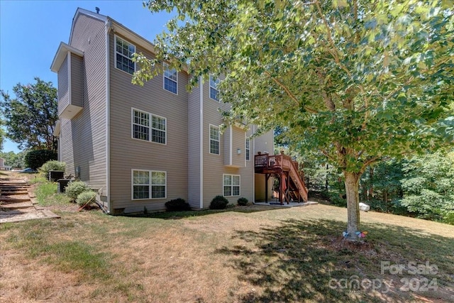 view of property exterior featuring a yard and a wooden deck