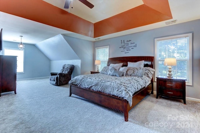 bedroom featuring light colored carpet, multiple windows, lofted ceiling, and ceiling fan