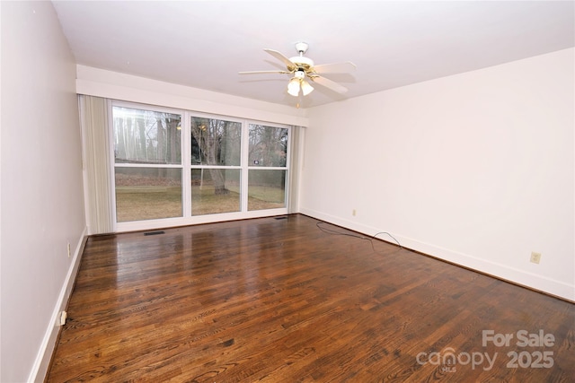 empty room with ceiling fan and dark hardwood / wood-style flooring