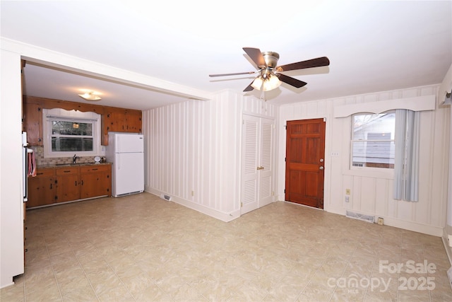 unfurnished living room with ceiling fan and sink