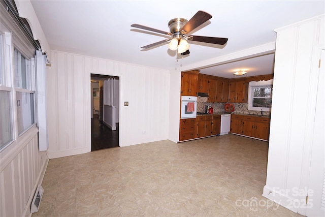 kitchen featuring white appliances, tasteful backsplash, ceiling fan, and sink