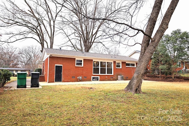 rear view of house with cooling unit and a lawn