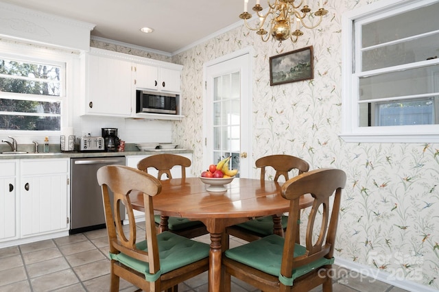 dining room featuring sink, light tile patterned flooring, ornamental molding, and a notable chandelier