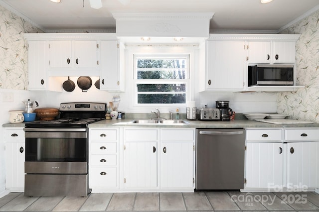 kitchen with sink, stainless steel appliances, white cabinetry, and crown molding