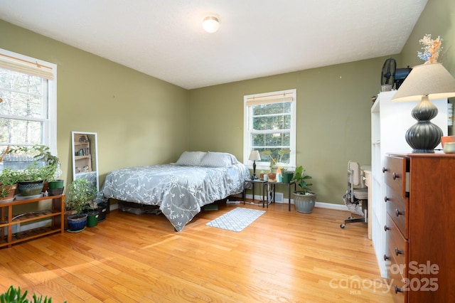 bedroom with wood-type flooring and multiple windows