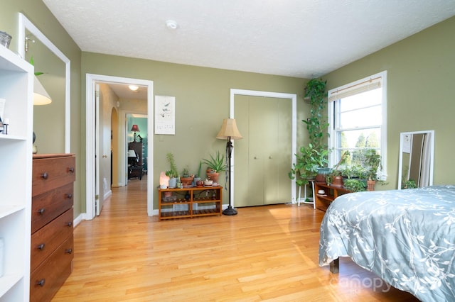 bedroom with a textured ceiling and light hardwood / wood-style floors