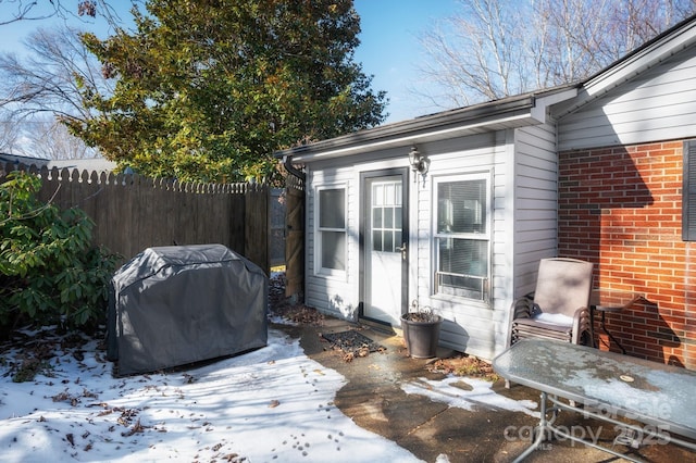 snow covered patio featuring a grill