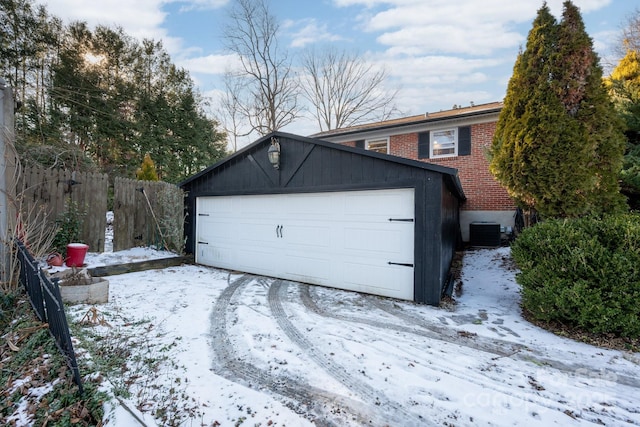 snow covered garage featuring cooling unit