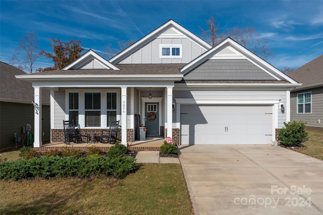 craftsman inspired home with a garage and covered porch