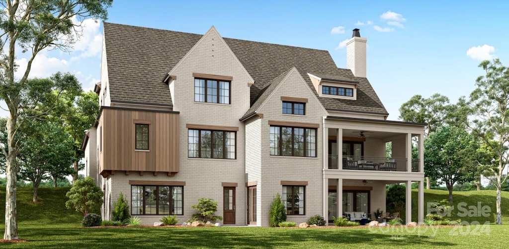 back of property with a yard, a balcony, and ceiling fan