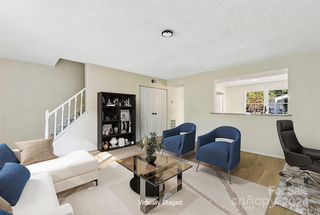 living room featuring a textured ceiling and light wood-type flooring