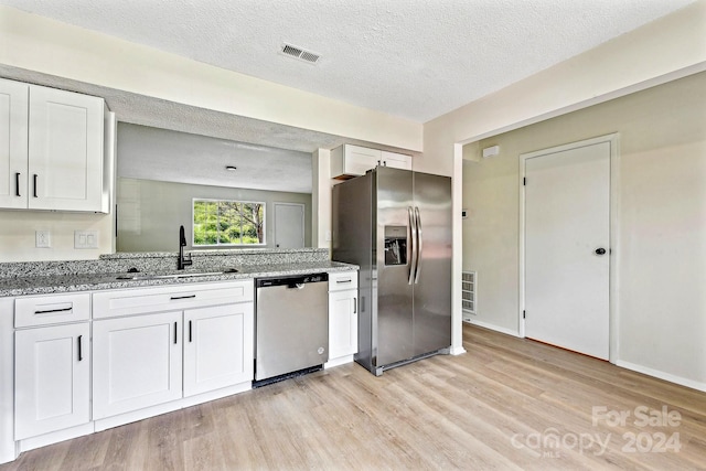 kitchen featuring light hardwood / wood-style flooring, white cabinets, stainless steel appliances, and sink