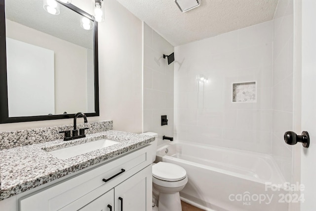 full bathroom featuring vanity, a textured ceiling, toilet, and tiled shower / bath combo