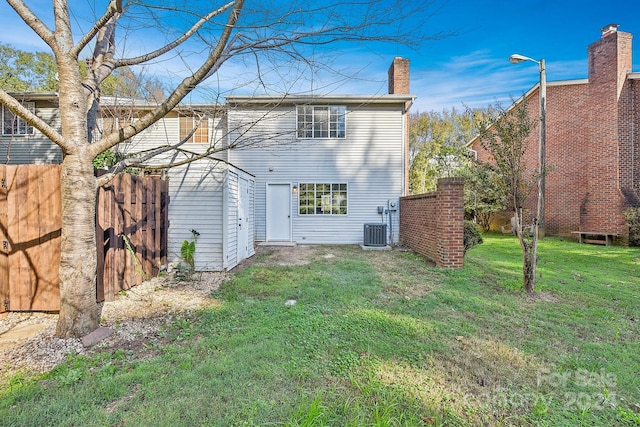 rear view of house featuring a lawn and central AC unit