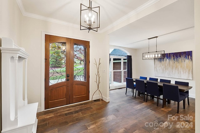 foyer featuring dark hardwood / wood-style flooring, ornamental molding, french doors, and an inviting chandelier