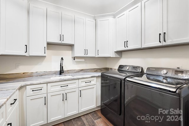 clothes washing area with separate washer and dryer, sink, cabinets, and dark hardwood / wood-style floors