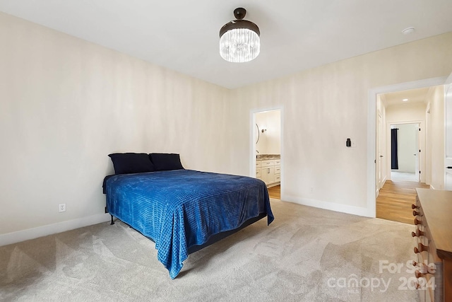 bedroom featuring ensuite bathroom and light colored carpet