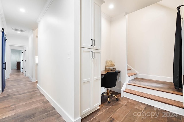 office featuring a barn door, crown molding, and dark hardwood / wood-style floors