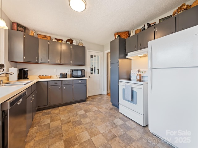 kitchen featuring sink, white appliances, and a textured ceiling