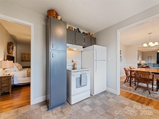 kitchen with a textured ceiling, a chandelier, and white appliances