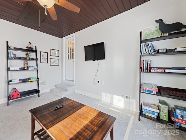 carpeted living room with ceiling fan and wood ceiling