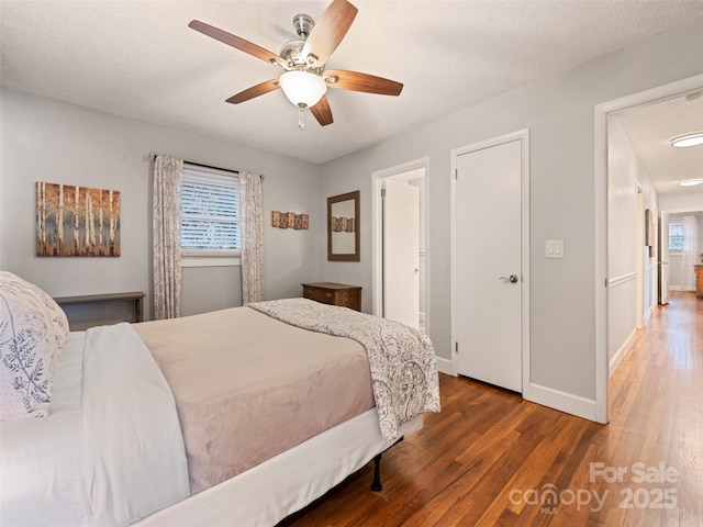 bedroom featuring hardwood / wood-style flooring, ceiling fan, and a textured ceiling