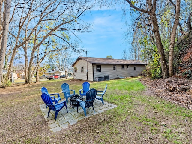 back of property featuring a yard, a fire pit, and a patio area