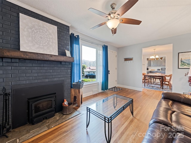 31 W End Cir, Waynesville, NC 28785 - living room featuring wood finished floors, a ceiling fan, a brick fireplace, baseboards, and a chandelier