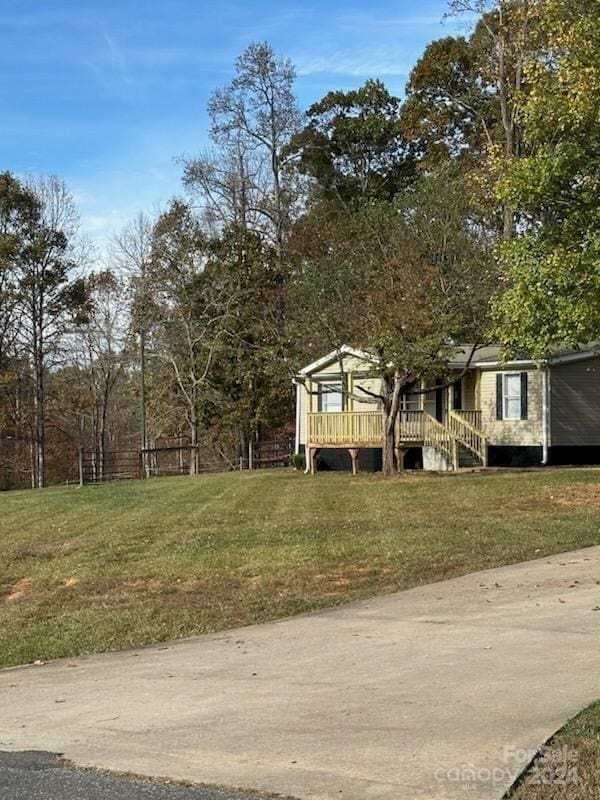 view of front of house featuring a wooden deck and a front yard