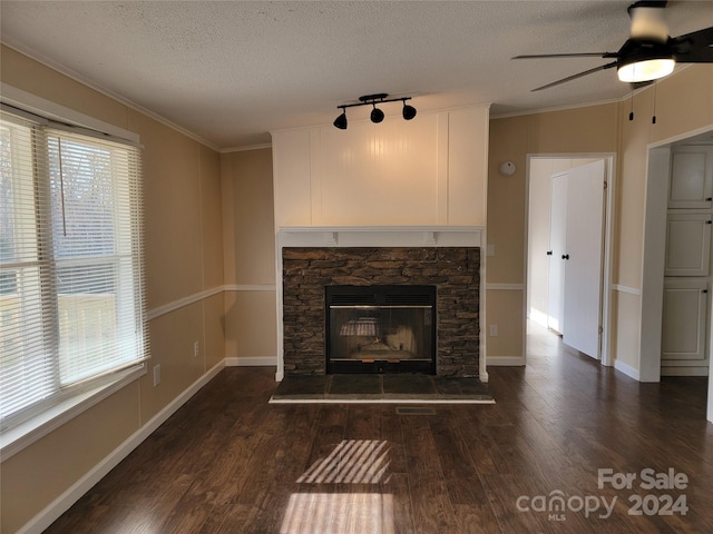 unfurnished living room featuring plenty of natural light, dark hardwood / wood-style flooring, ornamental molding, and a textured ceiling